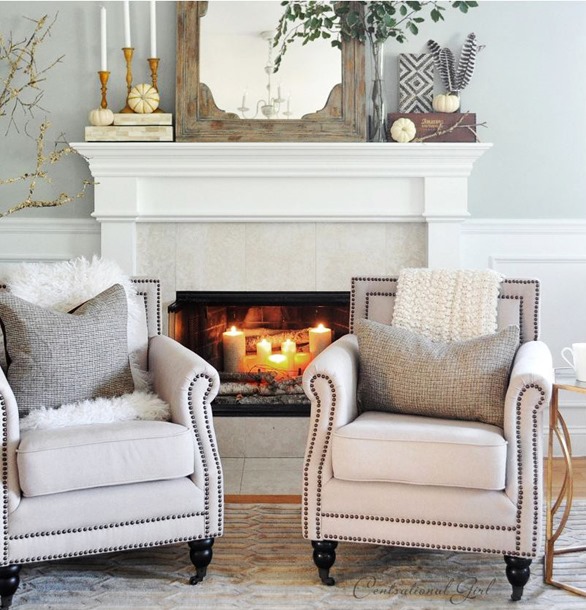 candles and birch logs in fireplace