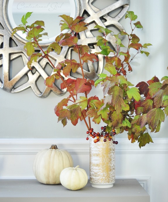 white and gold vase with leaves and berries